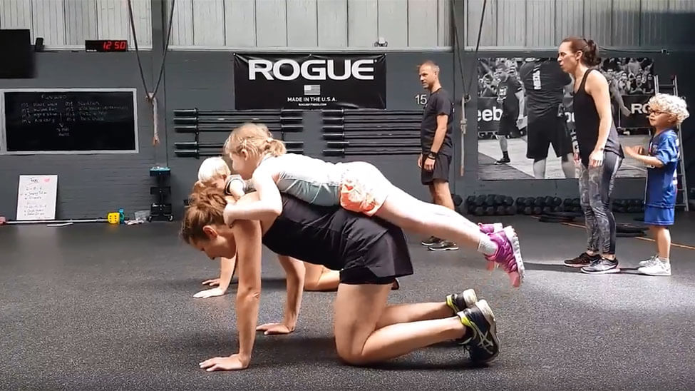 Children doing CrossFit exercises with their parents