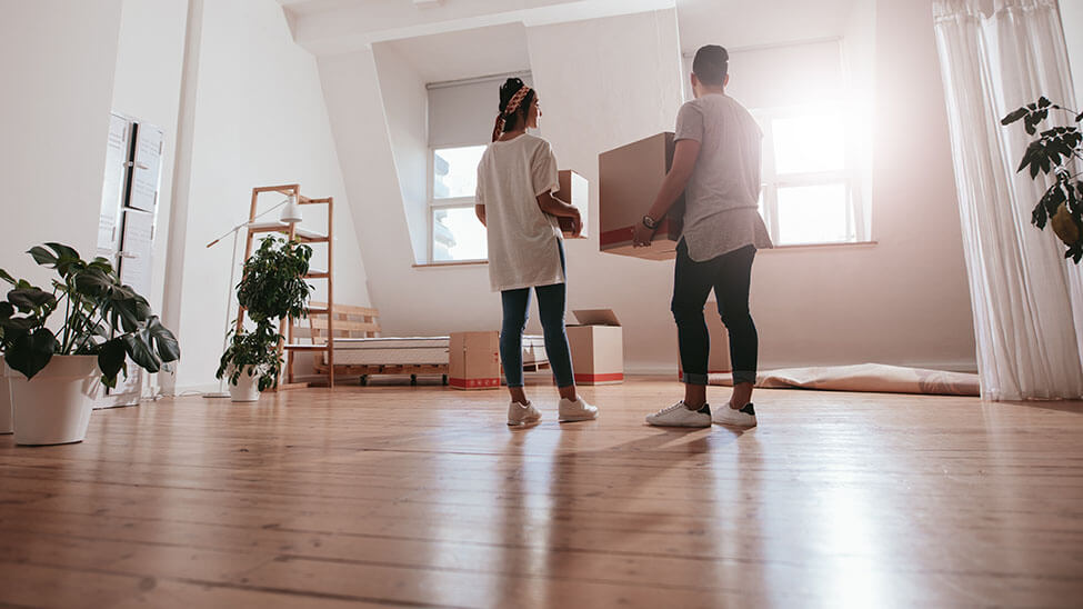 Young couple moves furniture in living room