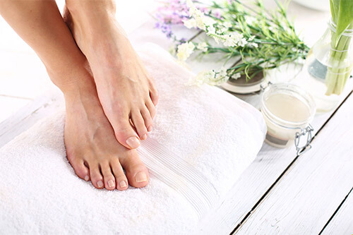 Foot care with towel, cream, oil and flowers
