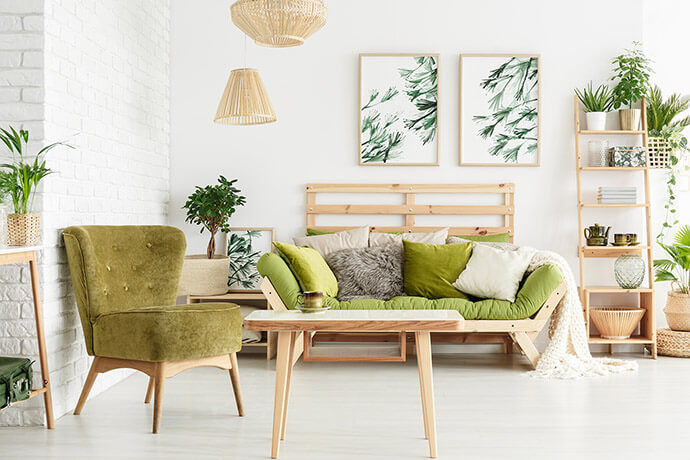Living room with green armchair and green sofa, with many wooden elements and plants