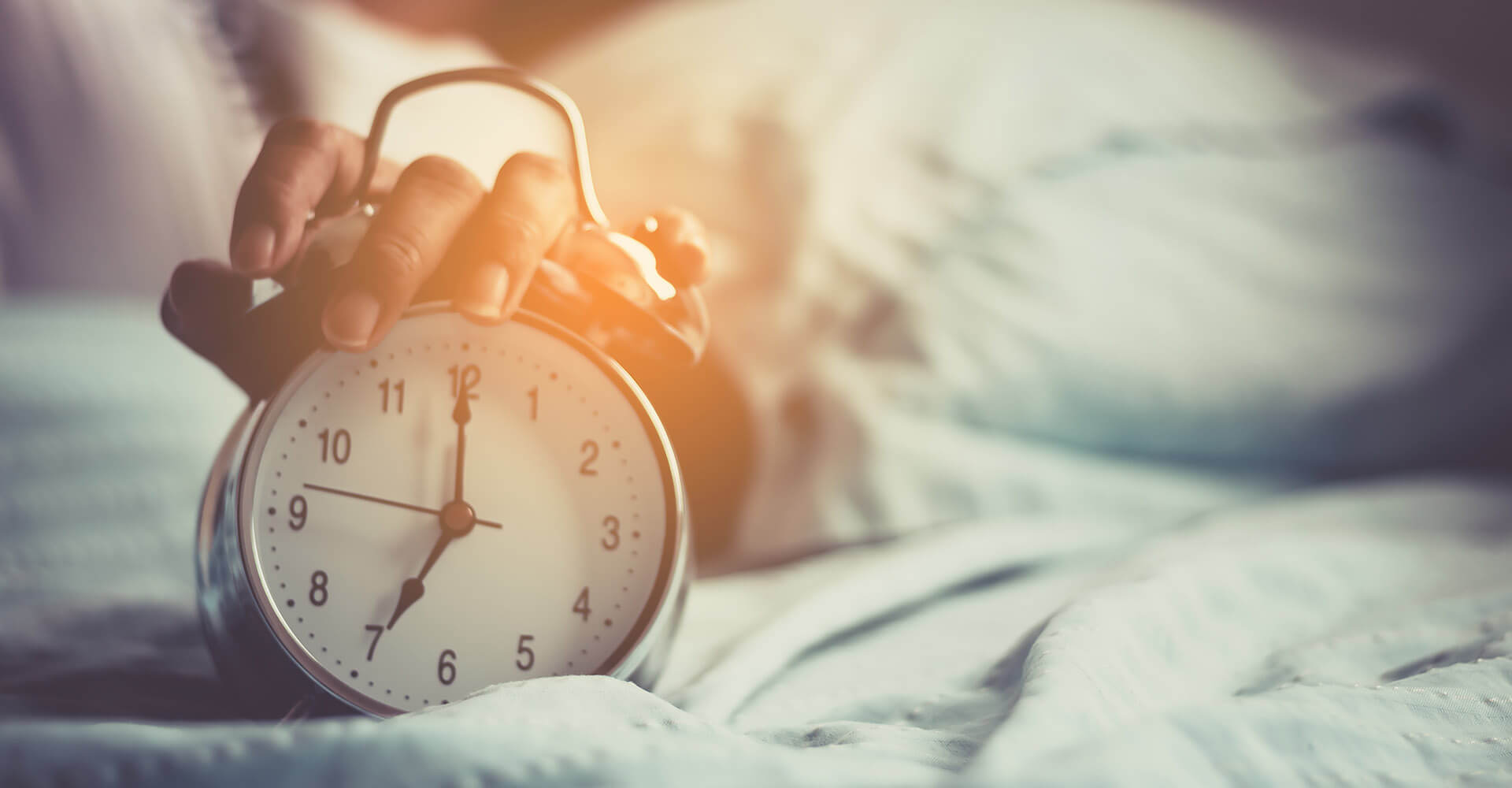 Woman with problems falling asleep turns off the alarm clock in the morning