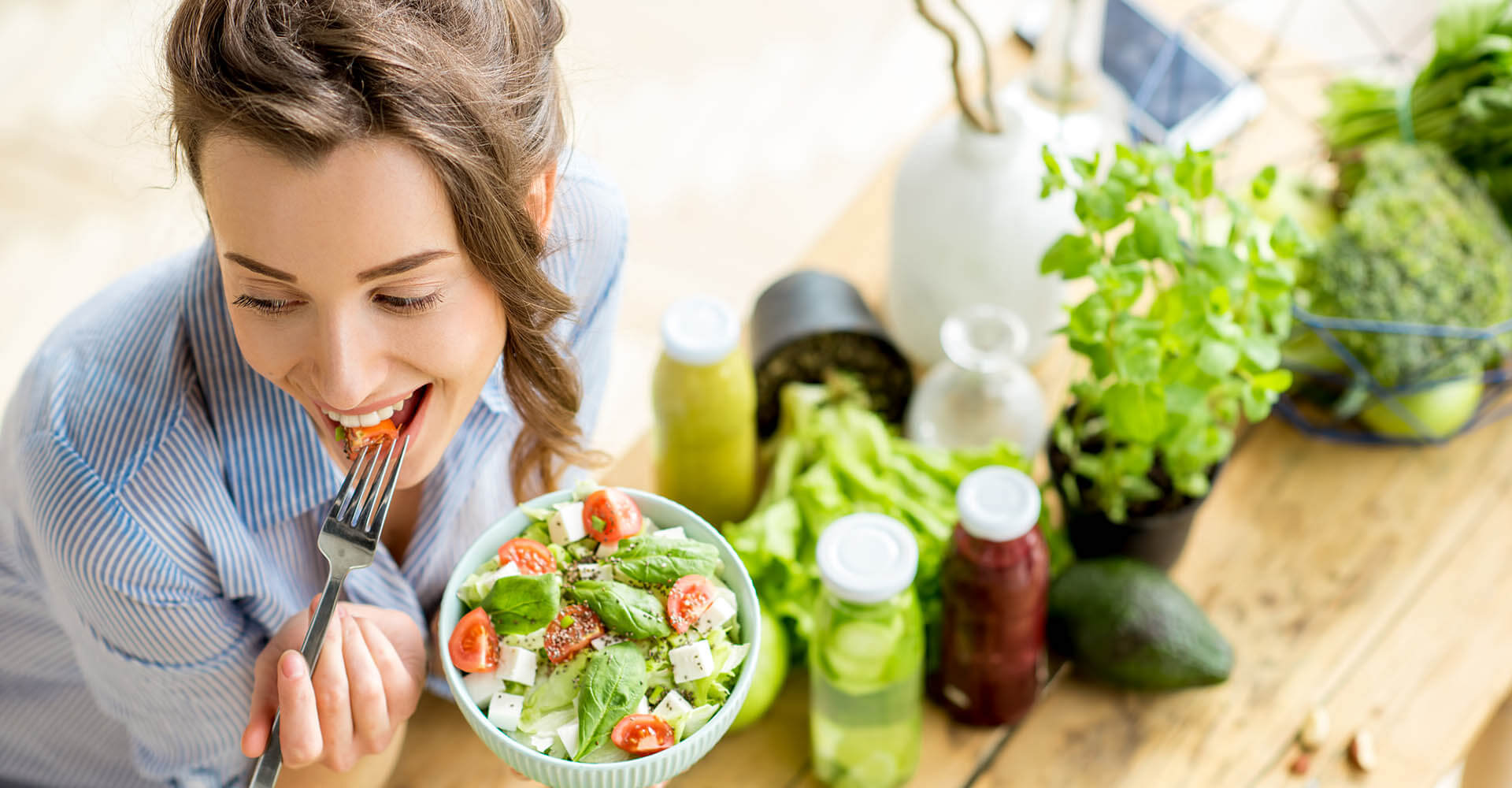 Woman eats a bowl of salad that she apparently prepared for herself