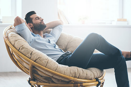 Man relaxes casually in armchair