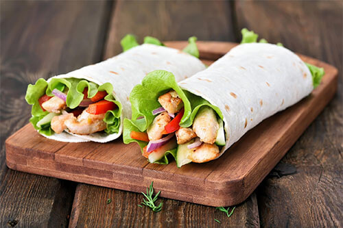2 wraps with protein rich food like turkey meat as filling