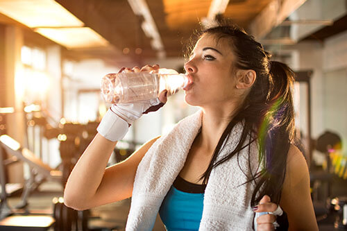 Woman drinks water during workout