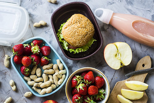 Meal Prep Breakfast with Strawberries, Peanuts, Apples and a Burger