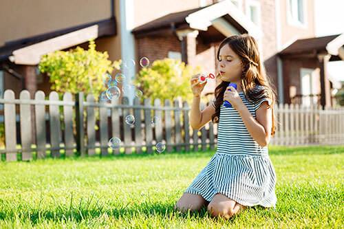 Girl playing in the garden with bubbles