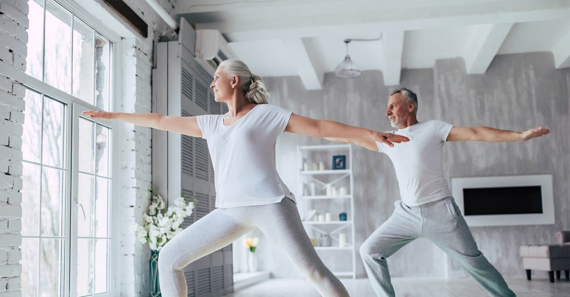 Elderly senior couple doing yoga exercise at home