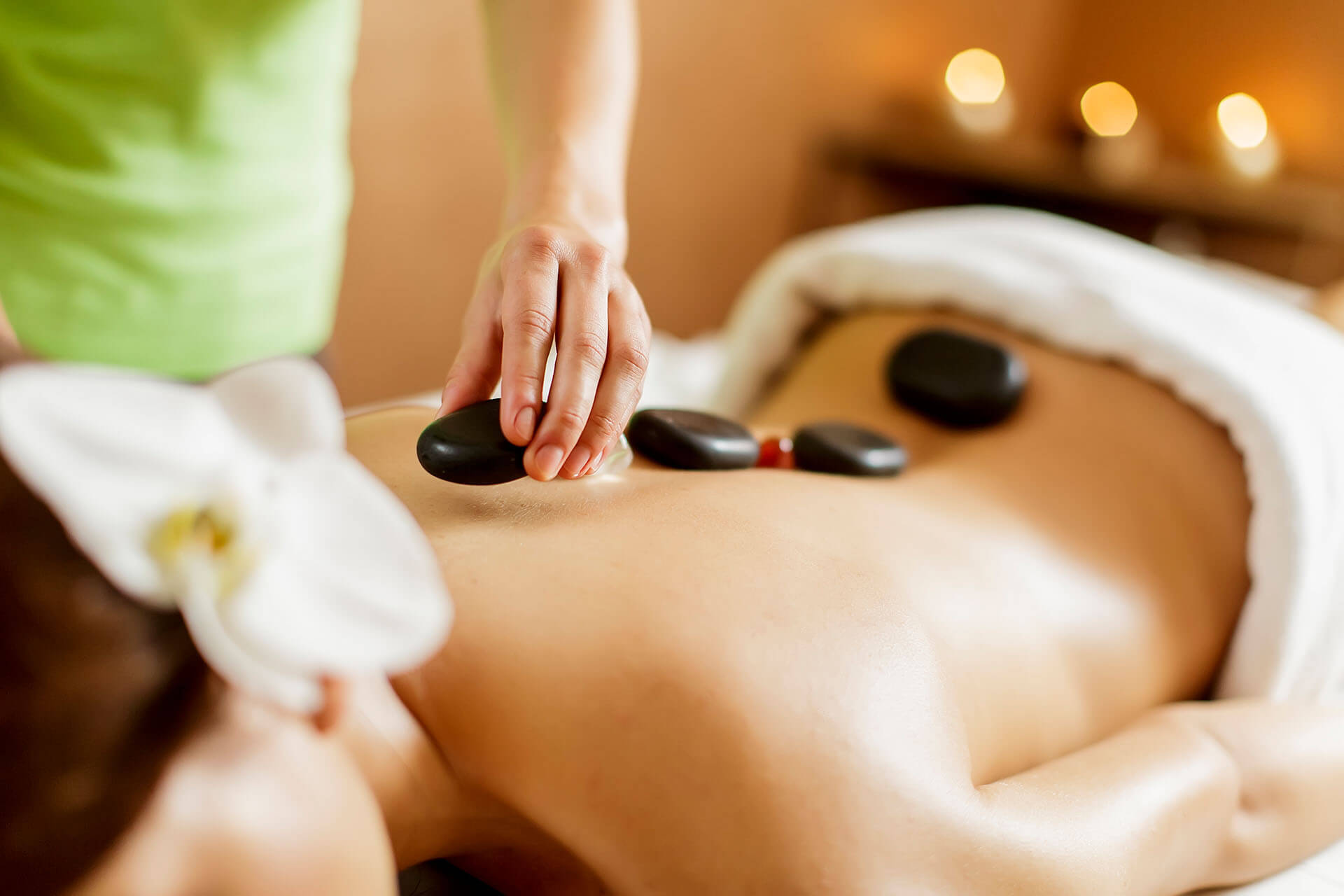 Woman gets massage at home with stones