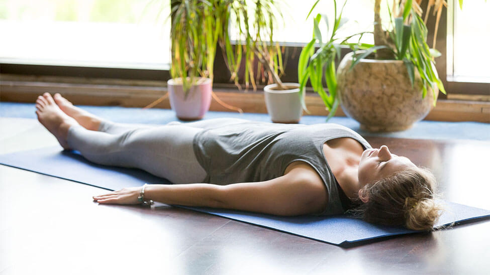 Woman doing autogenic training on yoga mat