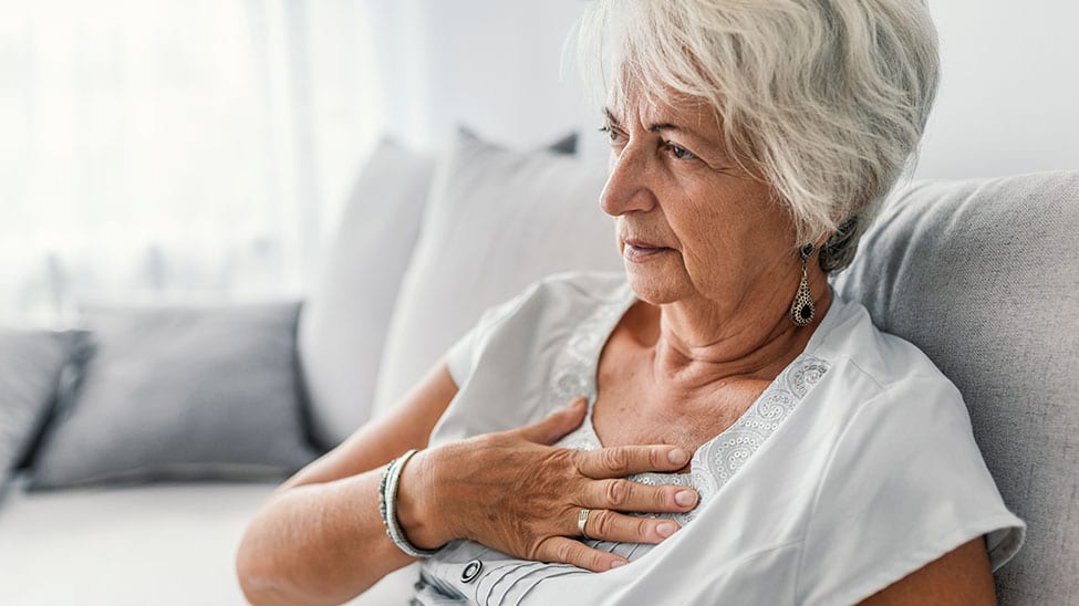 Older woman with heart palpitations holding chest