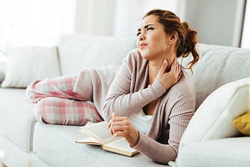 Woman on sofa with neck pain