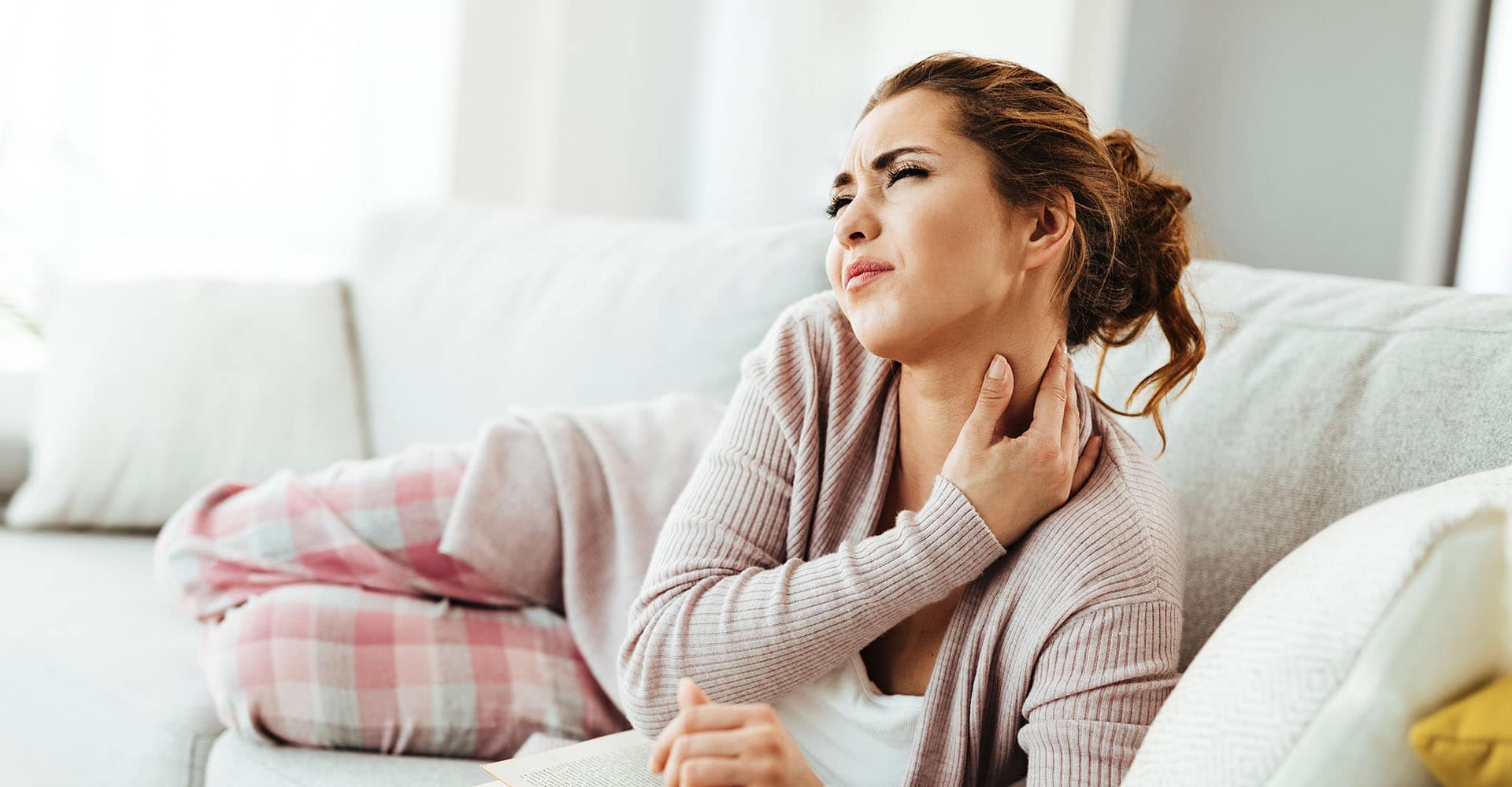 Woman on sofa with neck pain