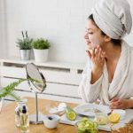 Woman doing facial care at mirror at home
