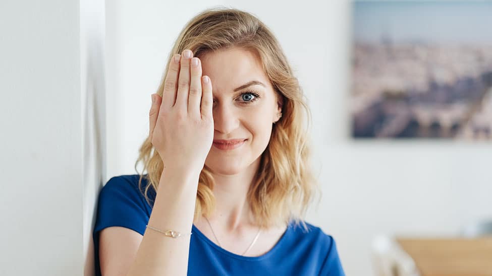 Woman doing eye yoga at home with one hand
