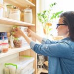 Woman organizing household and putting away shelf