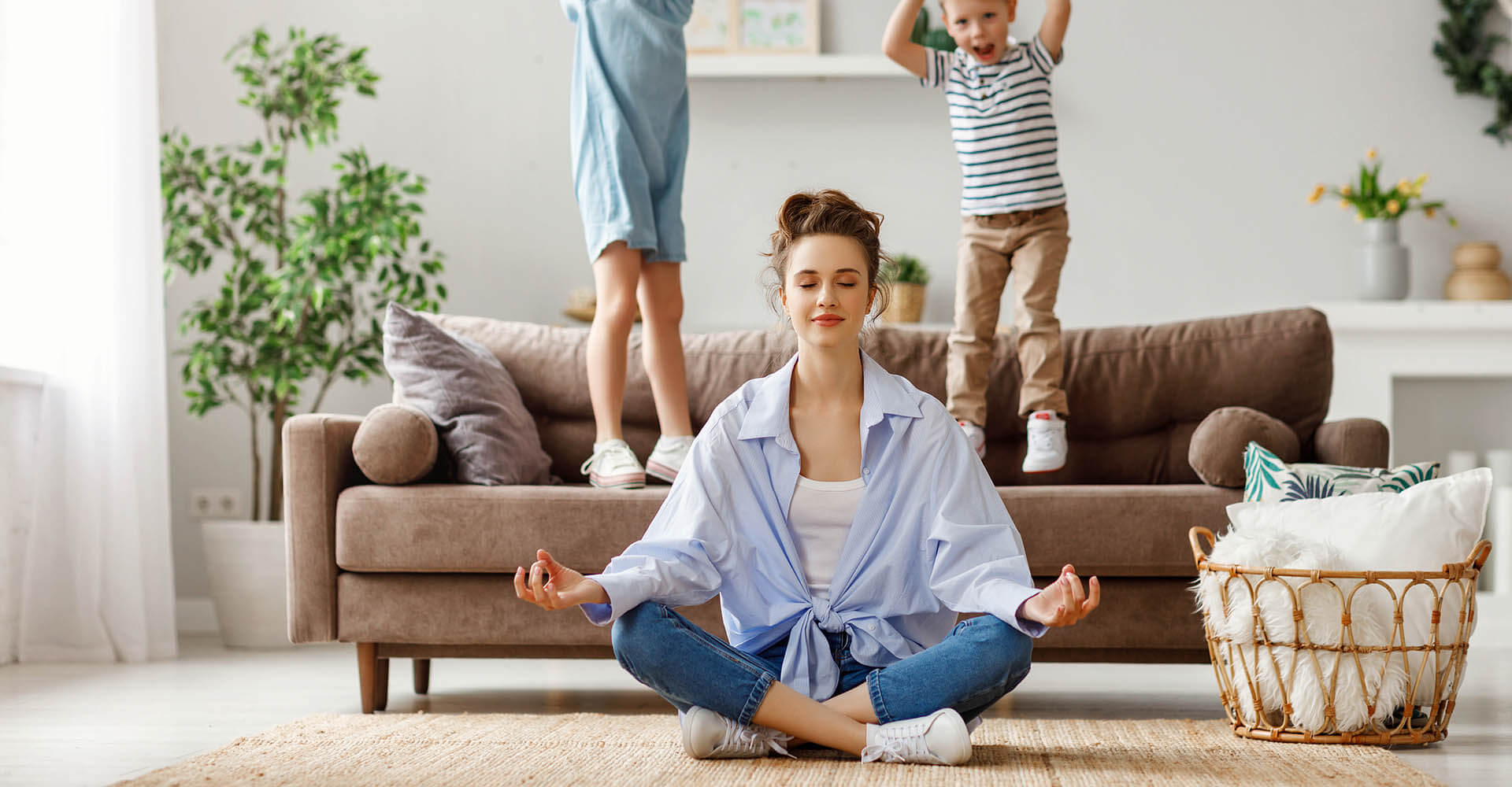 Mother performs relaxation exercise in the form of meditation next to her children
