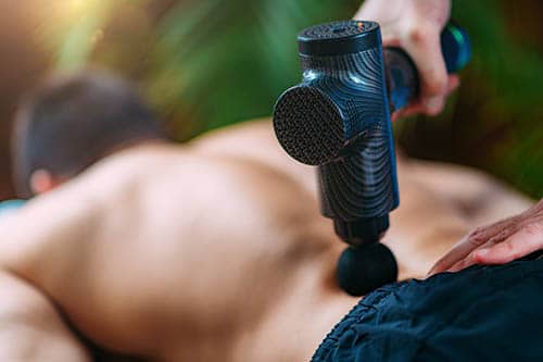 Miweba MM100 massage gun in use during massage