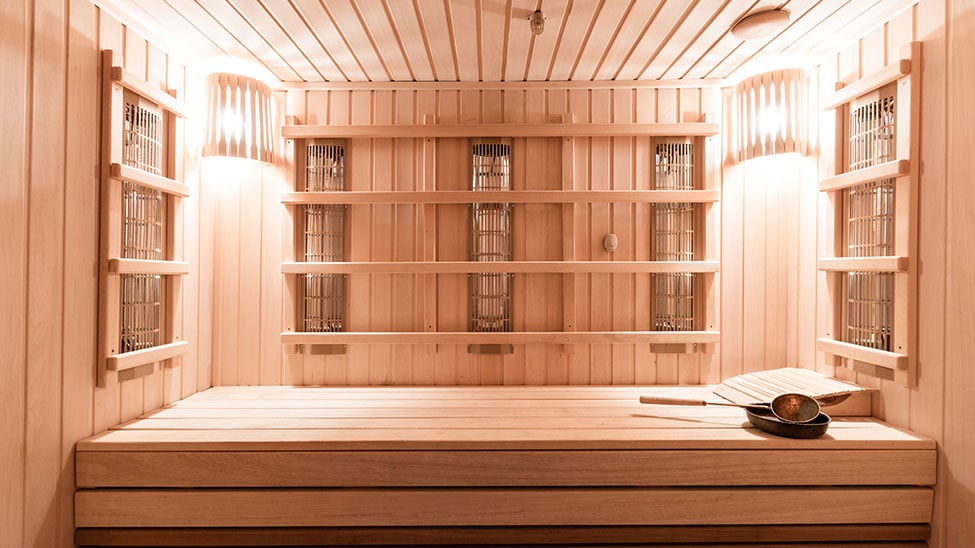 Innenaufnahme einer hellen, komplett aus Holz bestehenden Infrarot Sauna für Zuhause