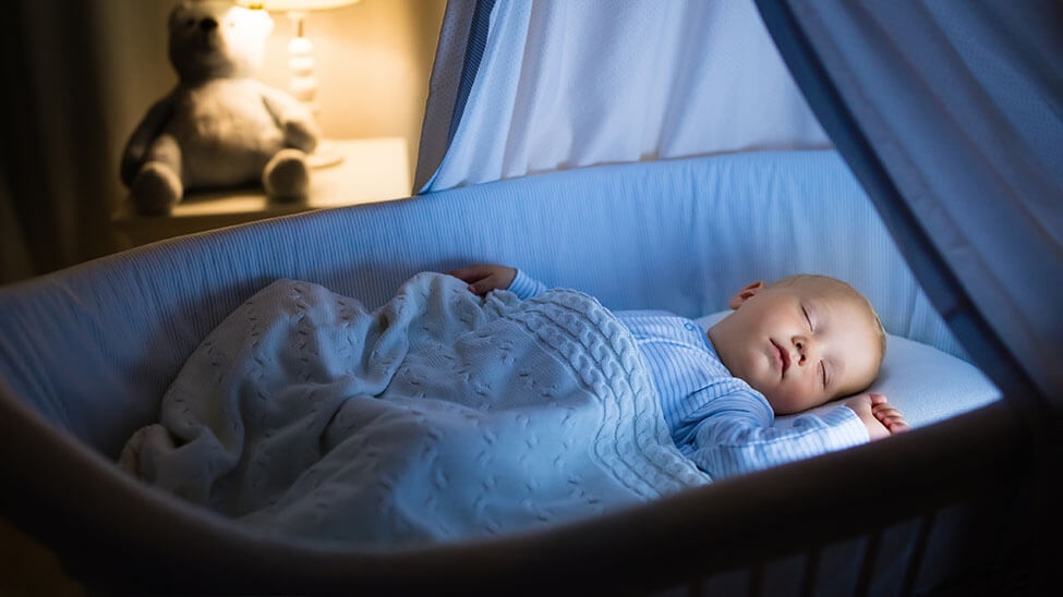 Baby schläft in kleinem Bettchen