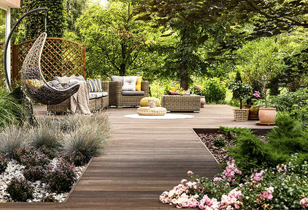Eine lange Holz-Terrasse mit großem Garten drumherum