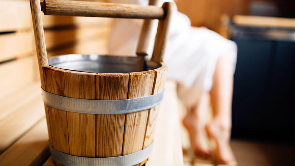 Eine Bottich mit Kelle drin als Saunazubehör in der Sauna