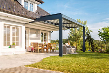 Blick auf Garten und Terrasse mit Lamellen-Terrassenüberdachung
