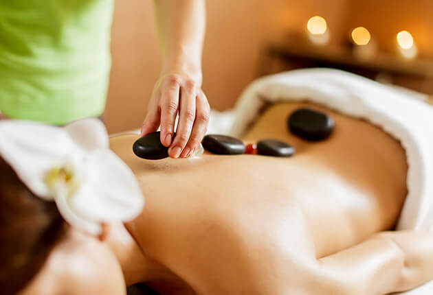 Frau entspannt während einer Massage im Rahmen einer Wellness-Session