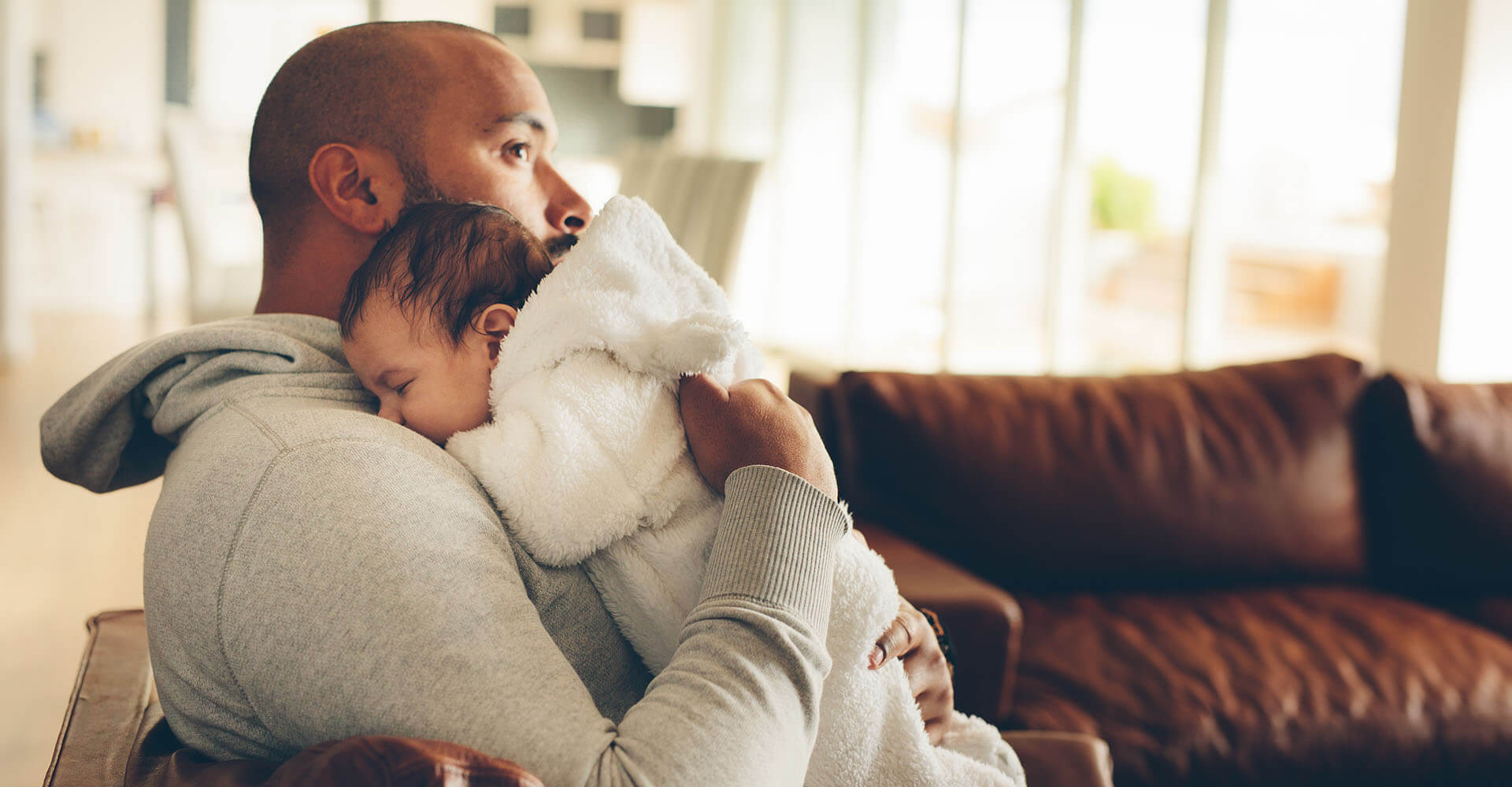 Baby schläft auf Schulter seines Vaters ein