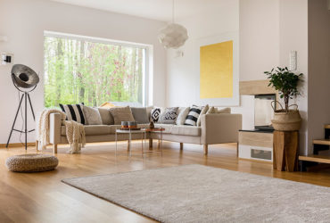 Cremefarbenes Wohnzimmer mit Sofa und extravaganter Lampe