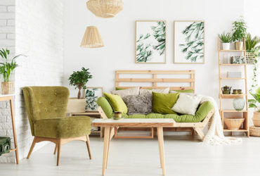 Wohnzimmer mit grünem Sessel und grünem Sofa, mit vielen Holzelementen und Pflanzen