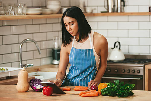 Frau macht in der Küche ein Gericht aus Gemüse zum schnellen Abnehmen
