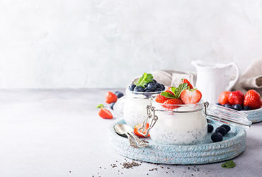 Verschiedene Superfood-Sorten wie Beeren, Erdbeeren und Chia-Samen zusammen mit Quark