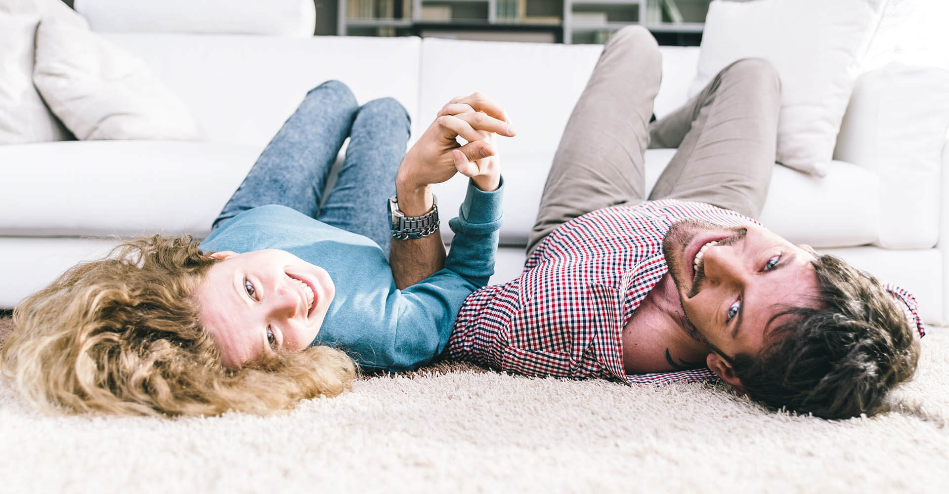 Paar wärmt sich zusammen in Wohnzimmer auf dem Boden für Yoga-Übungen auf