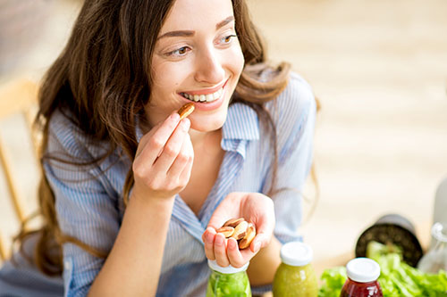 Frau isst Paranüsse im Rahmen einer ketogenen Diät
