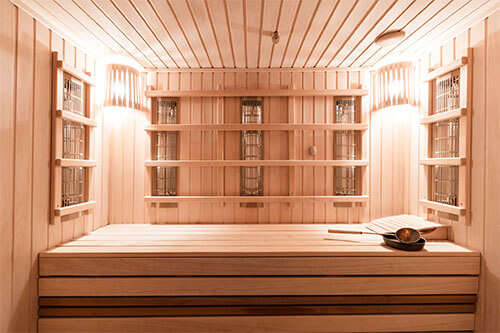 Innenaufnahme einer hellen, komplett aus Holz bestehenden Infrarot Sauna für Zuhause