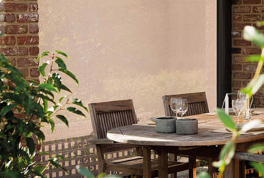 Seitenmarkise auf Terrasse vor Terrassenmöbeln wie Stühlen und Tisch