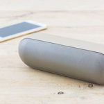 Helle Bluetooth Lautsprecher mit weißem Smartphone