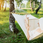 Frau liest Buch in Outdoor Hängematte
