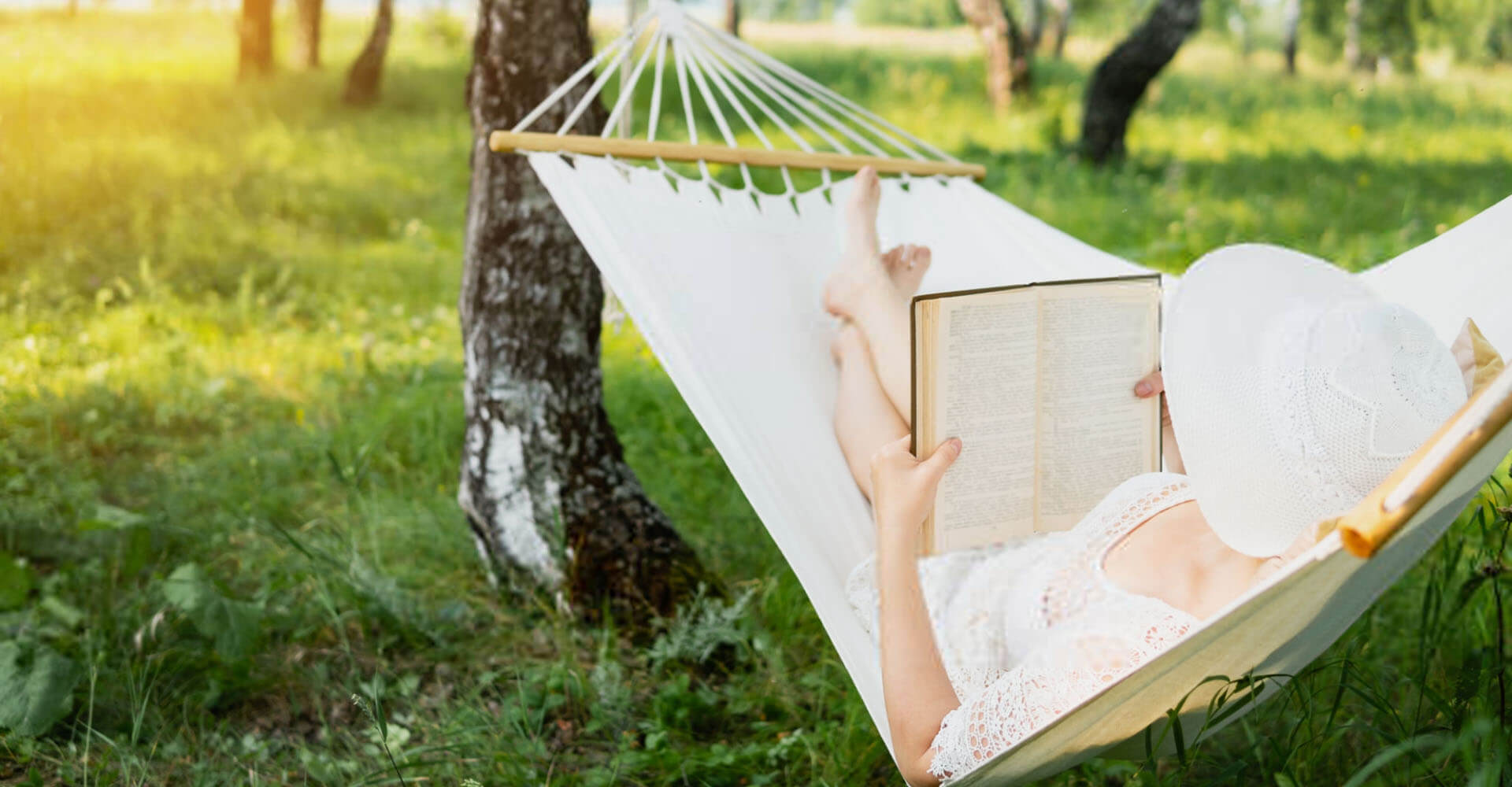 Frau liest Buch in Outdoor Hängematte
