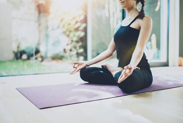 Frau macht Yoga auf Yogamatte