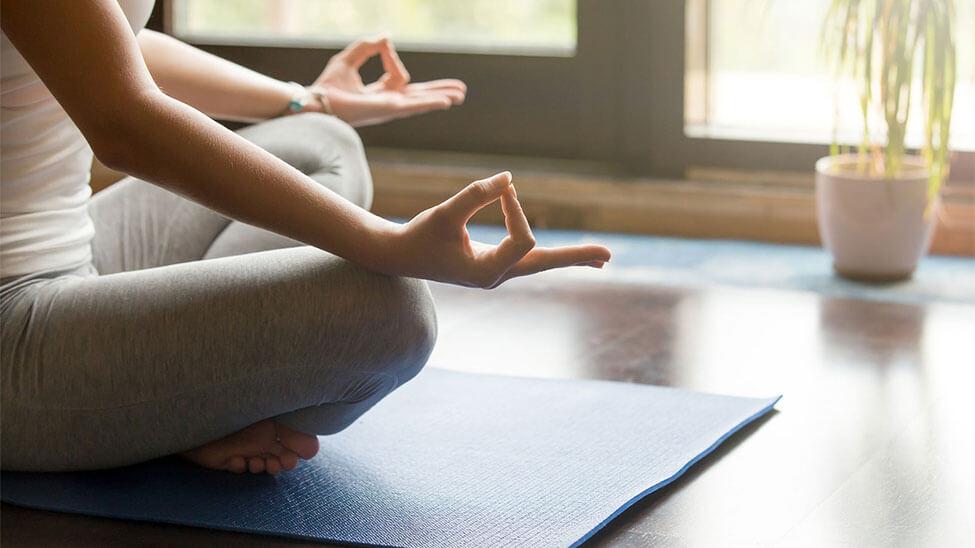 Frau meditiert auf Yogamatte