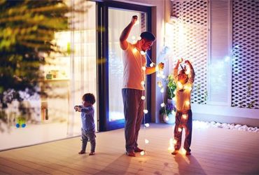 Familie mit Licherkette auf Terrasse