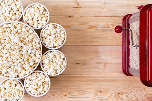 Popcornmaschine vor Kino-Eimern mit Popcorn