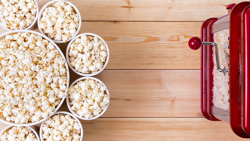Popcornmaschine vor Kino-Eimern mit Popcorn