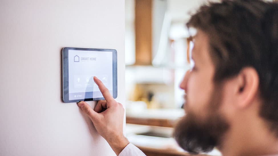 Mann regelt Temperatur via Smart Home Heizung