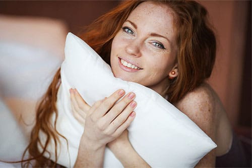 Frau mit Dinkelkissen im Bett