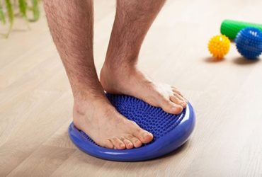 Mann auf Balancekissen
