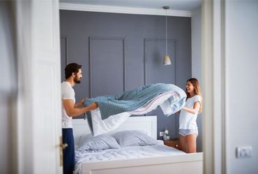 Paar mit Gewichtsdecke in Schlafzimmer