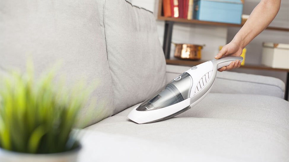 Handstaubsauger auf Wohnzimmer-Couch Handstaubsauger auf Wohnzimmer-Couch